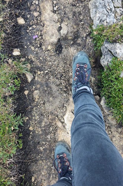 Wanderschuhe auf einem steinigen Waldweg