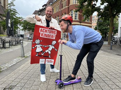 Achtung Kinder-Plakat wird gezeigt